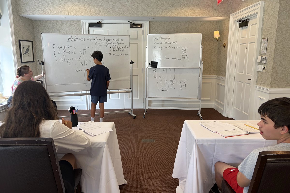 A CyberMath student presenting a mathematical proof at the board in front of the class